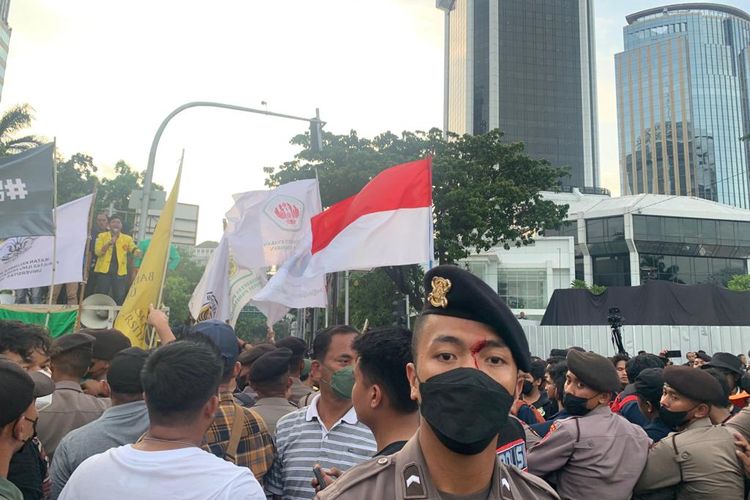 Peserta aksi unjuk rasa dari mahasiswa terlibat aksi saling dorong dengan petugas kepolisian setelah massa pengunjuk rasa berusaha memblokade persimpangan Jalan Medan Merdeka Barat dan Jalan Budi Kemuliaan, Jakarta Pusat, Jumat (30/9/2022).