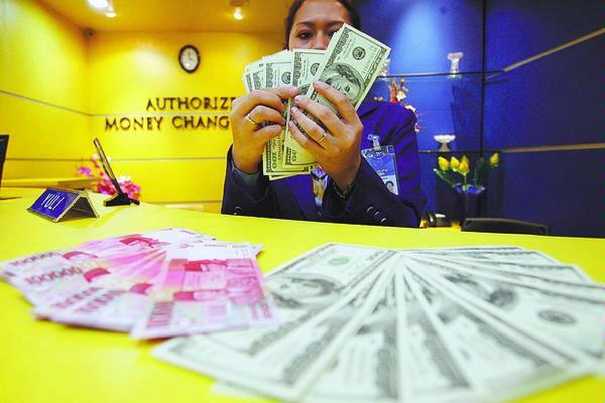 Petugas menghitung mata uang dollar AS di gerai pertukaran valuta asing di Plaza Mandiri, Jakarta, Selasa (7/10). Kurs dollar AS ditutup pada level Rp 9.555 atau melemah dibandingkan dengan penutupan kurs sehari sebelumnya, yaitu Rp 9.570.  