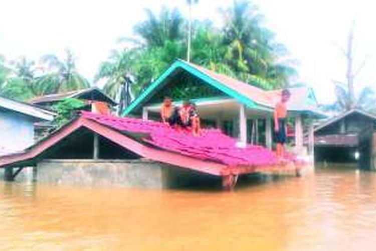 Anak-anak bertahan di atap rumah lokasi banjir Desa Cinendang, Kecamatan Gunung Meriah, Aceh Singkil, Selasa (29/11/2016)