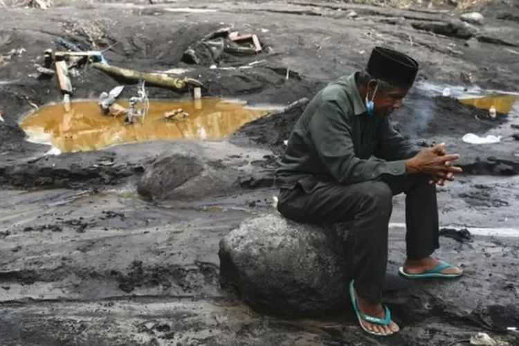 Musmin, 55, mengunjungi sebuah lokasi yang dia yakini sebagai tempat cucunya terkubur materi vulkanis Gunung Semeru.