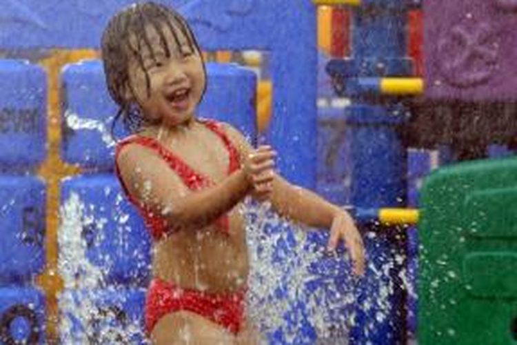 Seorang anak kecil bermain air di sebuah air mancur di kota Taipei, Taiwan saat suhu udara kota itu mencapai 37,9 derajat Celcius. Gelombang udara panas juga melanda China yang menewaskan 10 orang di Shanghai.