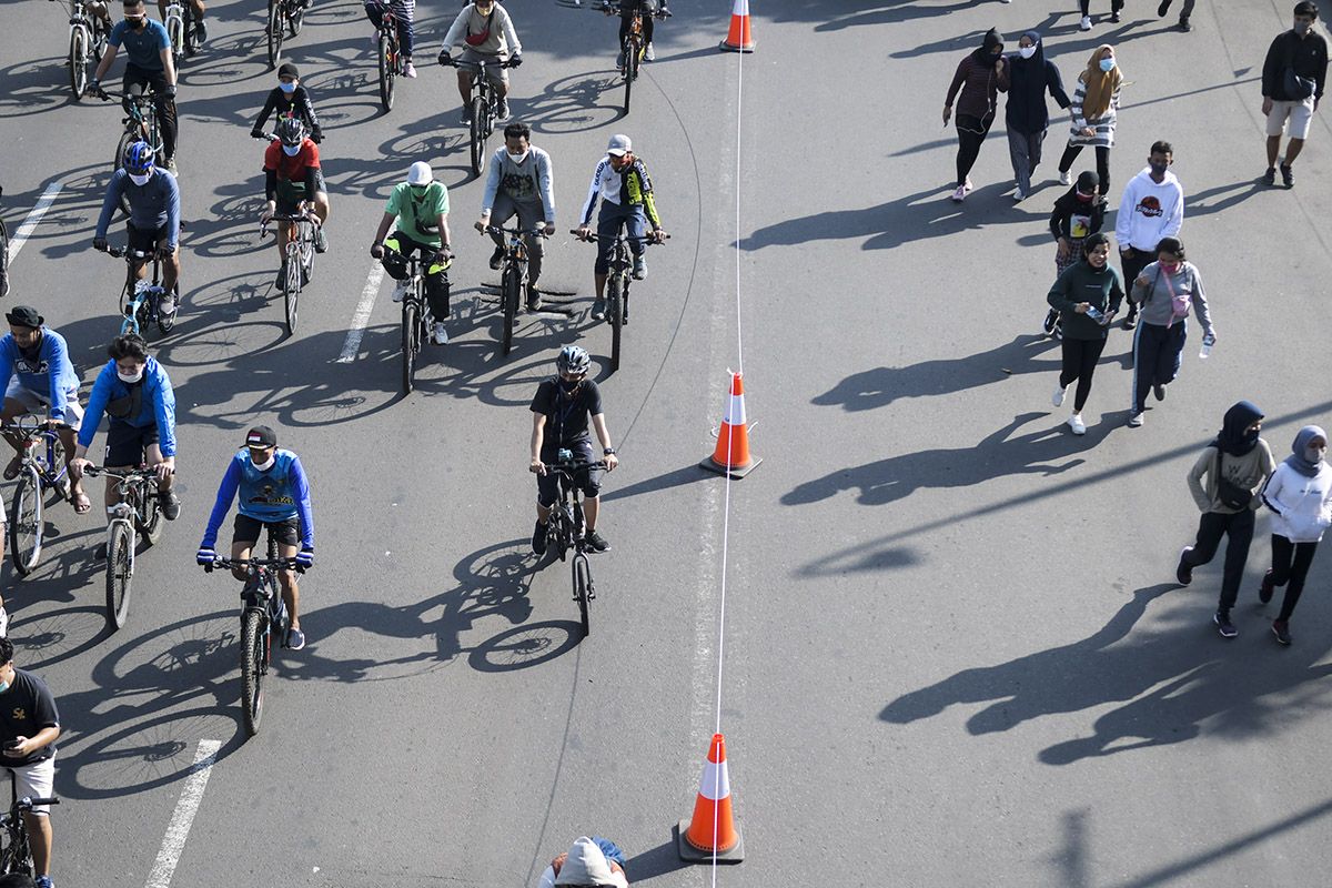 Warga berolahraga saat hari bebas berkendara atau car free day (CFD) di kawasan Jalan MH Thamrin, Jakarta, Minggu (21/6/2020). Dinas Perhubungan (Dishub) Provinsi DKI Jakarta memisahkan jalur untuk pesepeda, olahraga lari, dan jalan kaki saat CFD pertama pada masa pembatasan sosial berskala besar (PSBB) transisi.