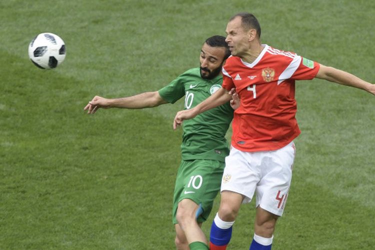 Bek Timnas Rusia, Sergei Ignashevich (kanan), berduel dengan penyerang Arab Saudi, Mohammed Al-Sahlawi, dalam laga pembukaan Piala Dunia 2018 di Stadion Luzhniki, Moskow, 14 Juni 2018.