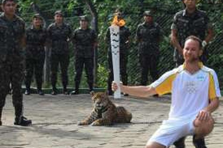 Fisioterapis Brasil Igor Simoes Andrade berpose bersama Juma si jaguar dalam upacara Obor Olimpiade di Manaus, 20 Juni 2016.