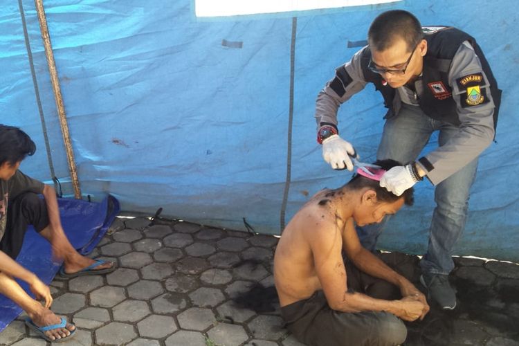 Seorang petugas tengah membersihkan gelandangan psikotik di Rumah Singgah Dinsos Cianjur setelah sebelumnya dijemput dari jalanan kota Cianjur.