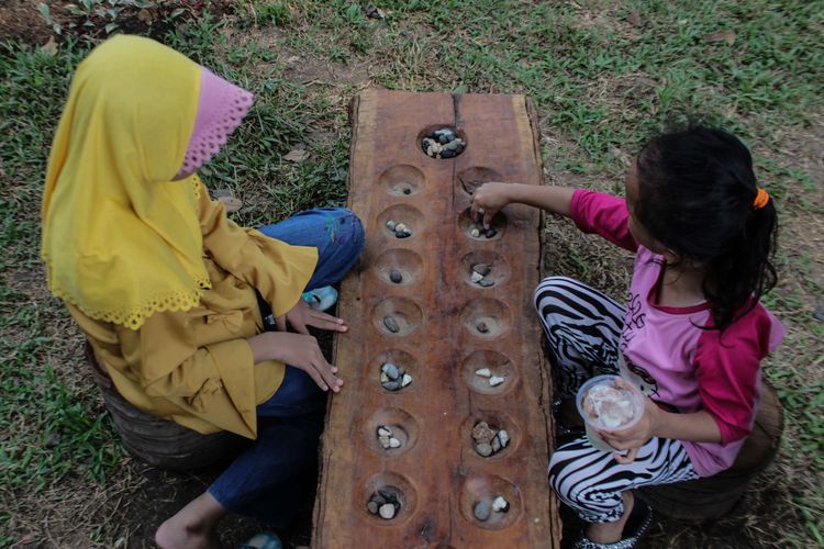 Pengunjung menikmati Taman Tomang Rawa Kepa dengan bermain permainan tradisional yang disediakan taman, tepatnya di Jalan Tomang Raya, Tomang, Grogol, Jakarta Barat, Minggu (15/12/2019). Taman yang dibangun oleh Suku Dinas Kehutanan Jakarta Barat memiliki nuansa khas Betawi di dalamnya.