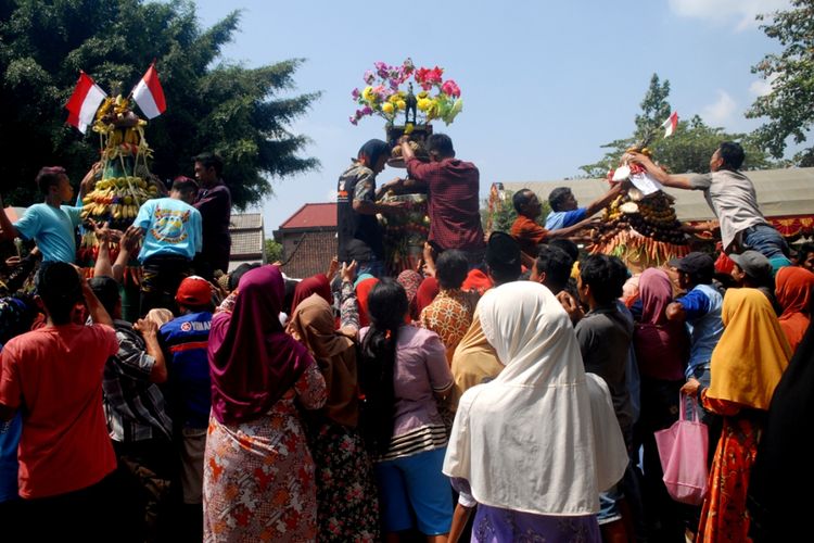 Warga Desa Sumber Jatipohon, Kecamatan Grobogan, Kabupaten Grobogan, Jawa Tengah berebut Gunungan setinggi 2,5 meter dalam tradisi sedekah bumi di obyek wisata Jatipohon, Grobogan, Kamis (9/8/2018).