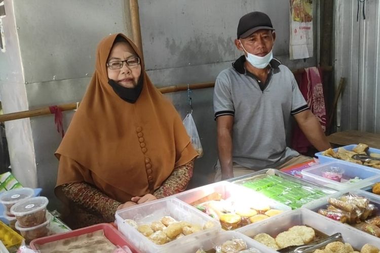 Caption: Siti Rokhana (kiri), pedagang jajanan pasar di Pasar Rejoso Nganjuk yang mendapat bingkisan dari Presiden Jokowi