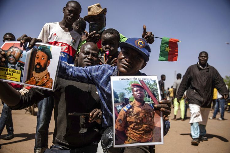 Seorang pria memegang potret Letnan Kolonel Paul Henri Sandaogo Damiba yang telah mengambil alih kendali negara di Ouagadougou Selasa 25 Januari 2022.