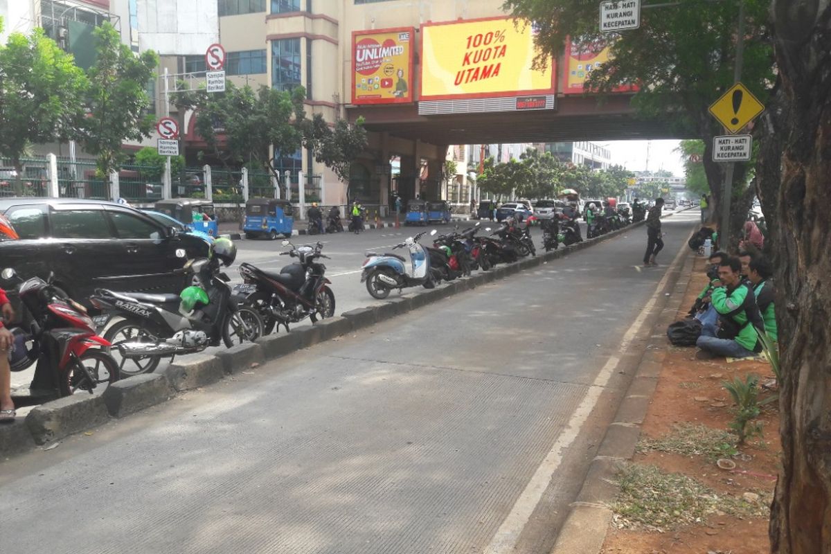 Sejumlah sepeda motor milik pengemudi ojek online diparkir di tepi separator jalur Transjakarta di Mangga Dua, Jakarta Utara, Mingu (15/4/2018)