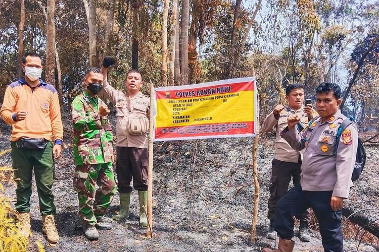 Petugas gabungan menyegel lokasi karhutla setelah api dipadamkan secara manual di Desa Suka Maju, Kecamatan Rambah, Kabupaten Rokan Hulu, Riau, Senin (11/7/2022).