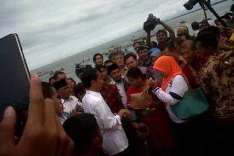Jokowi memberikan amplop ke pedagang ikan di Bengkulu.