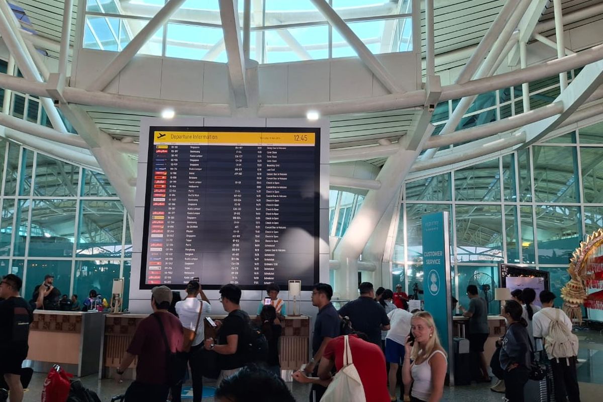 Sejumlah penumpang mancanegara tengah mengantre di depan loket layanan informasi di Terminal Internasional Bandara I Gusti Ngurah Rai, pada Kamis (14/11/2024). KOMPAS.com/ Yohanes Valdi Seriang Ginta