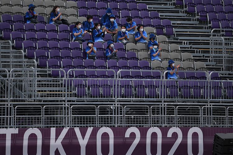 Sejumlah relawan beristirahat sambil memberikan dukungan saat pertandingan panahan Olimpiade Tokyo 2020 di Yumenoshima Park Archery Field, Tokyo, Jepang, Senin (26/7/2021). Penyelenggaraan Olimpiade yang diselenggarakan tanpa penonton dari kalangan umum tersebut merupakan keputusan di tengah kondisi darurat Covid-19 yang sedang diberlakukan di Ibu Kota Jepang.