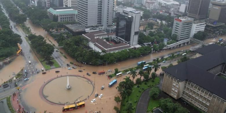 Banjir di kawasan bundaran air mancur di samping Patung Arjuna Wiwaha, Jalan MH Thamrin, Jakarta, Senin (9/2/2015). Curah hujan yang tinggi mengakibatkan sejumlah tempat di ibu kota terendam banjir. KOMPAS / LASTI KURNIA