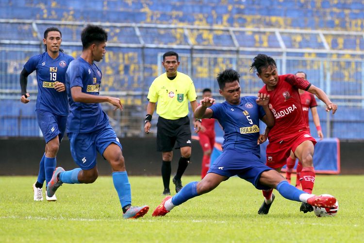 Pemain Arema FC Bagas Adi berebut bola dengan pemain Madura United Moch Kevy saat latih tandingyang berakhir dengan skor 2-2 di Stadion Kanjuruhan Kepanjen Kabupaten Malang, Jawa Timur, Senin (15/03/2021) sore.
