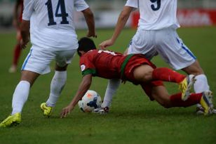 Pemain Indonesia, Maldini Pali (tengah) dihadang dua pemain Uzbekistan, Abdusalimov (kiri) dan Shomurodov Eldor pada turnamen sepak bola Piala AFC U-19 di Stadion Thuwunna, Yangon, Myanmar, Jumat (10/10/2014). Indonesia menyerah 1-3. 