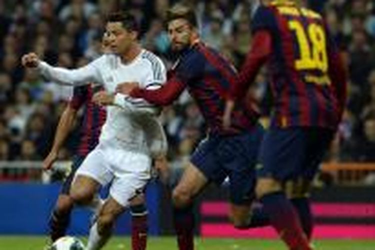 Gelandang Real Madrid, Cristiano Ronaldo (kiri) berebut bola dengan bek Barcelona Gerard Pique, pada pertandingan Primera Division La Liga, di Santiago Bernabeu, Minggu (23/3/2014).