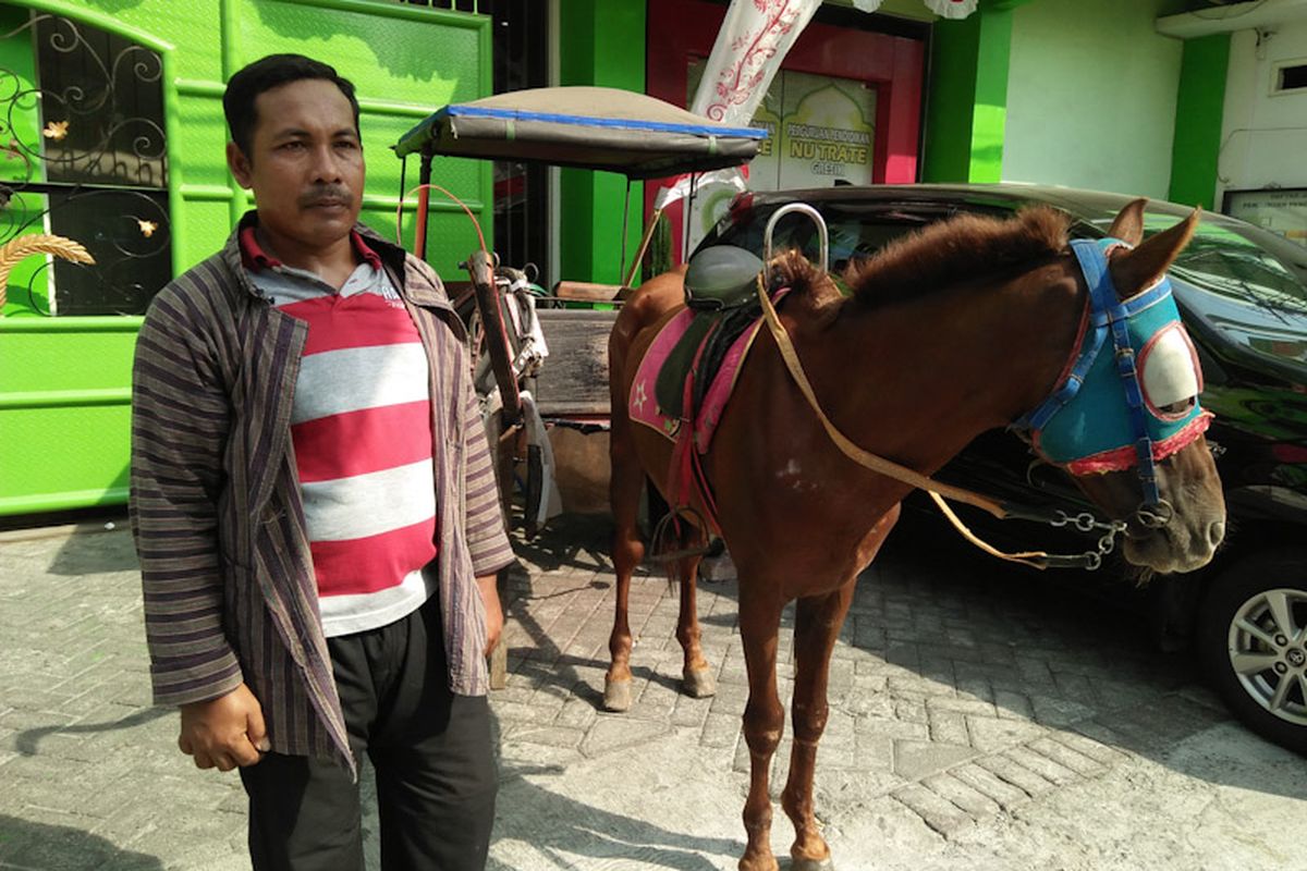 Salikun bersama delman miliknya, saat mendapat order untuk menyemarakkan pawai siswi MINU Tratee Putri Gresik menyambut tahun baru hijriyah dan momen Agustusan, Jumat (12/8/2022). *** Local Caption *** Salikun bersama delman miliknya, saat mendapat order untuk menyemarakkan pawai siswi MINU Tratee Putri Gresik menyambut tahun baru hijriyah dan momen Agustusan, Jumat (12/8/2022).