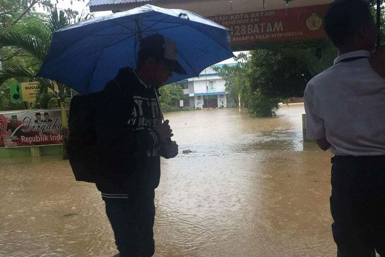 Salah seorang siswa SMPN 28 Batam Kota mengurungkan niatnya ke sekolah. Saat ini SMPN 28 terendam banjir akibat hujan deras yang mengguyur Kota Batam sejak Senin malam kemarin.