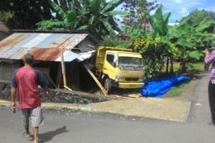 Sebuah mobil Dump Truck menabrak rumah warga di Manado.