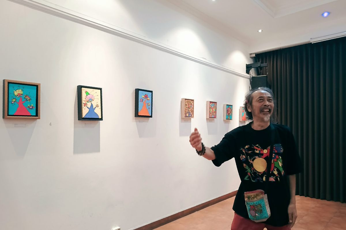 Seniman Daniel Kho saat menjelaskan 26 karya bergaya Neo Pop-Art dalam remang cahaya yang nyaris senyap, warna-warni menyala dari balik kanvas dalam pameran tunggal bertajuk La Wet di Wisma Jerman, Surabaya