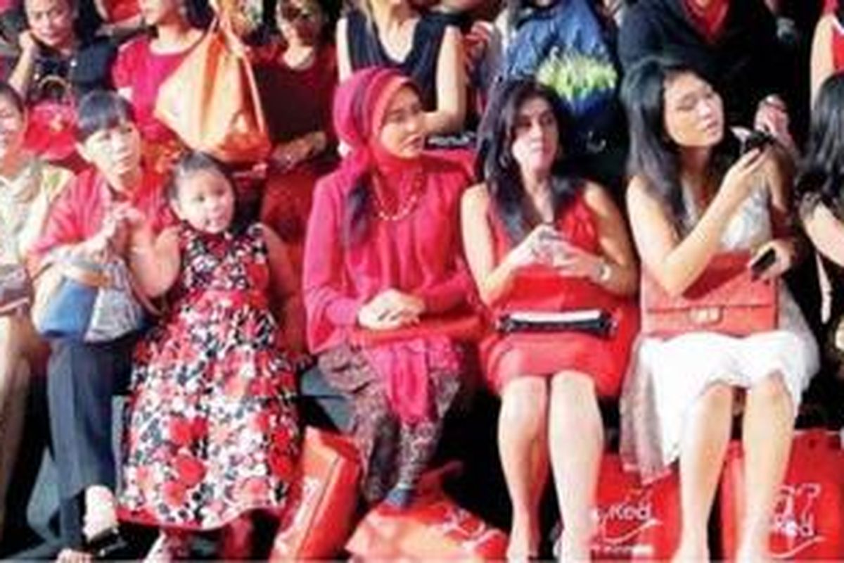 Dress code dengan nuansa merah. Merah tak harus terlihat pada busana, bisa juga pada aksesori.