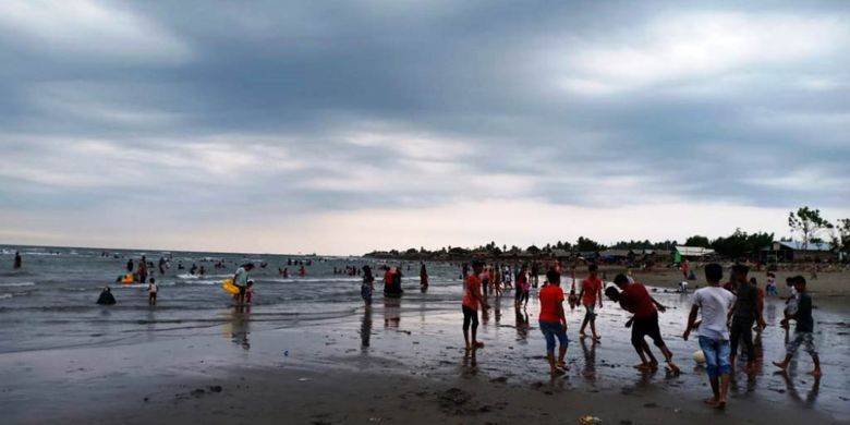 Wisatawan bermain sepak bola di Pantai Ujong Blang, Kota Lhokseumawe, Aceh, Rabu (16/5/2018).