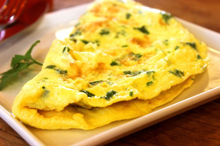 Ilustrasi omelet dengan tambahan susu dan sayuran.
