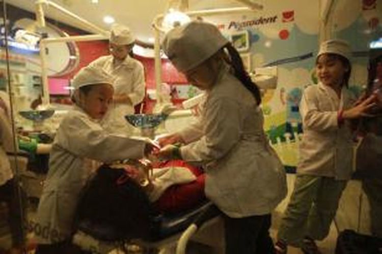 Anak-anak menjadi dokter gigi saat bermain di Kidzania, Pacific Place, Jakarta, Senin (5/8/2013). Kidzania menjadi salah satu tempat pilihan anak-anak untuk mengisi libur Lebaran. Wahana yang terdiri dari 71 paviliun permainan ini menawarkan 130 profesi kepada anak-anak, memiliki luas 7.500 meter persegi, berkapasitas bagi 1.200 anak kecil dan 600 orang dewasa.  