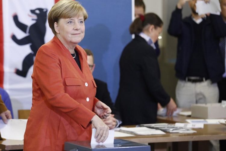 Kanselir Jerman Angela Merkel memberikan suara dalam Pemilu Jerman, Minggu (24/9/2017) waktu setempat. 