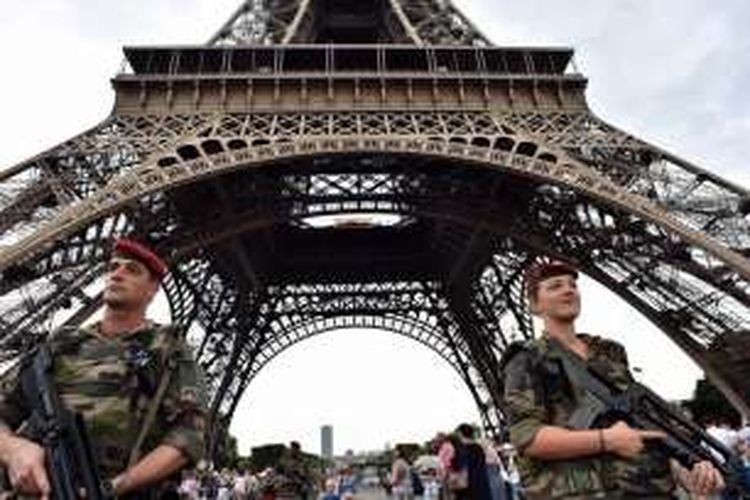 Tentara berjaga di kaki Menara Eiffel, Paris, Perancis. Menara ini berada di sebuah taman yang luas, yang disebut Champs de Mars. 