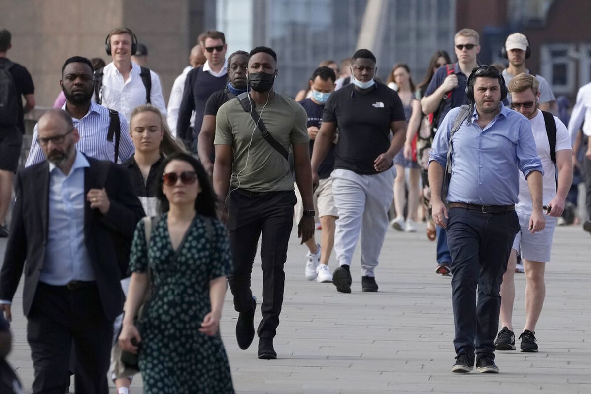 Orang-orang berjalan di atas Jembatan London, rute jalan kaki yang populer bagi para komuter dari stasiun kereta api dan tabung Jembatan London di London, menuju Kota London, selama kesibukan pagi Senin, 19 Juli 2021. 