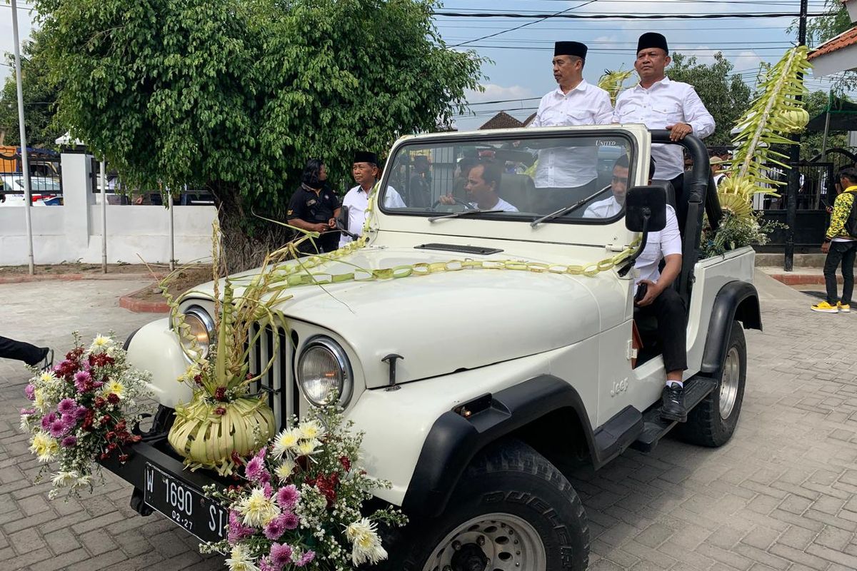 Bakal pasangan calon bupati dan wakil bupati, Hari Wuryanto-Purnomo Hadi menumpang mobil jeep dihias dan diarak massa bak pengantin saat mendaftar di Komisi Pemilihan Umum Kabupaten Madiun, Jawa Timur, Rabu (28/8/2024).