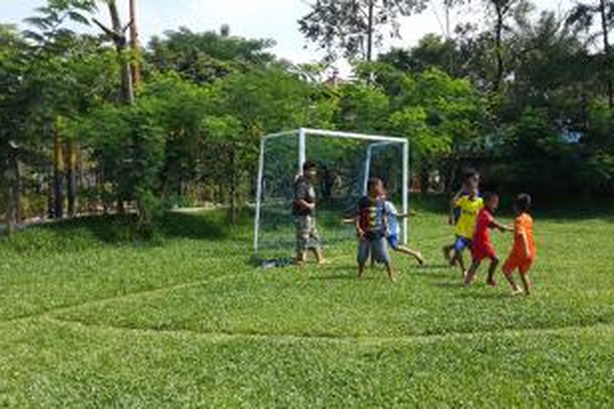 Anak-anak sedang bermain sepak bola di lapangan sepak bola mini TPA Rawa Kucing, Tangerang, Minggu (5/4/2015)