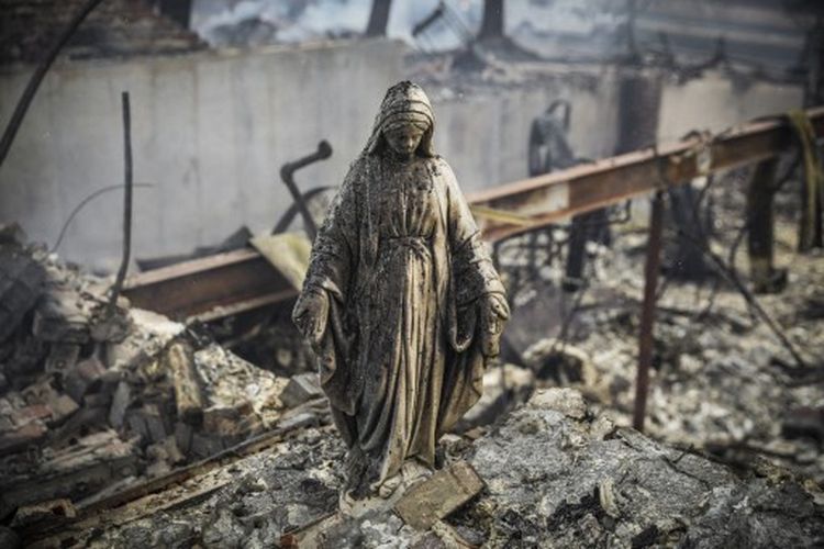 Patung Perawan Maria tetap berdiri di tengah puing-puing rumah pada 31 Desember 2021 setelah Kebakaran hutan di Colorado, Amerika Serikat. 