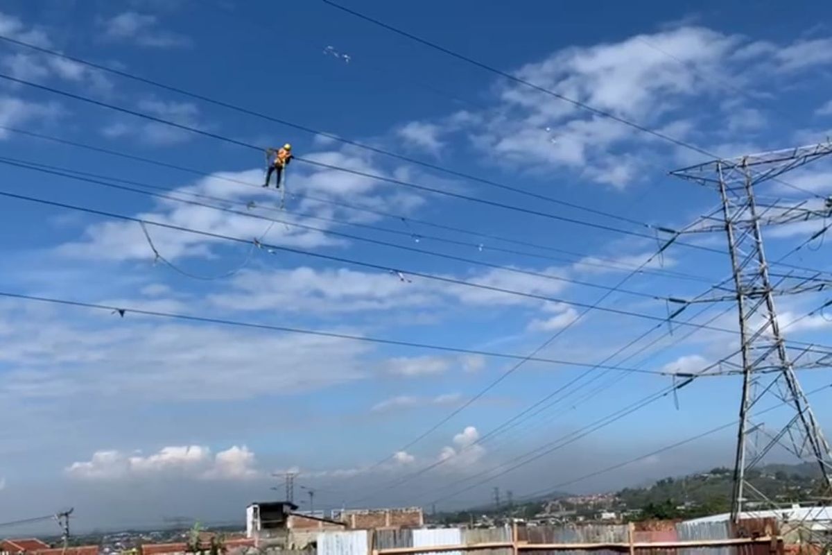 Petugas PLN sedang membersihkan benang layang-layang yang terlilit di kabel listrik jaringan SUTT maupun SUTET, Bandung, Jawa Barat, Selasa (17/8/2021).