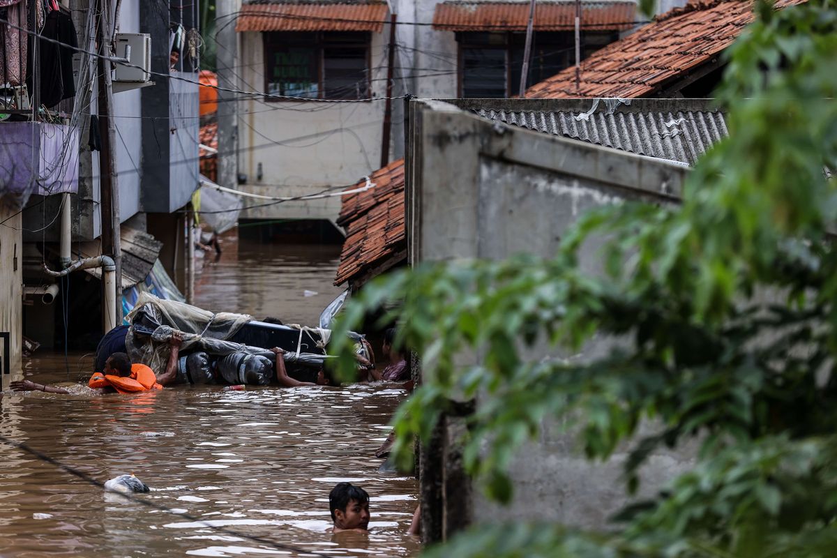 Warga menggunakan perahu rakitan mengevakuasi warga di Pejaten Timur, Pasar Minggu, Jakarta Selatan, Senin (8/2/2021). Banjir setinggi 30-150 cm yang melanda tiga RW di Pejaten Timur itu disebabkan oleh luapan air Sungai Ciliwung.