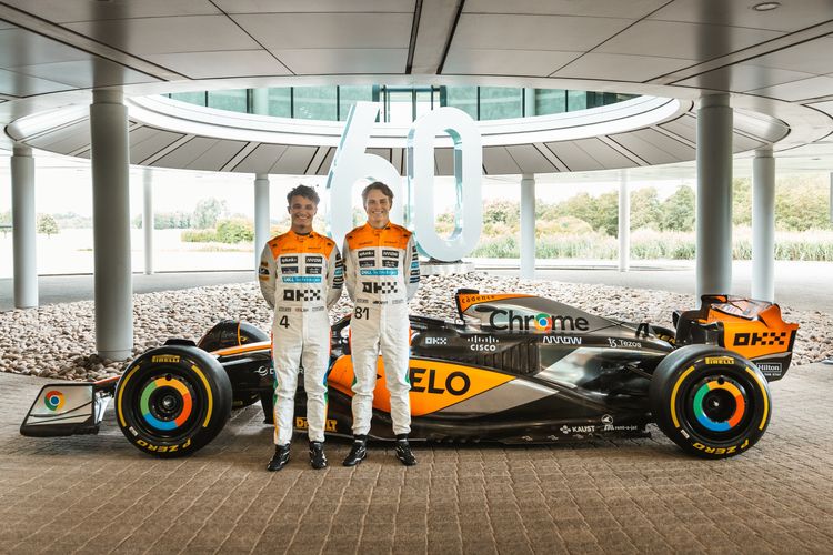 Pebalap Formula 1 dari tim McLaren, Lando Norris (kiri) dan Oscar Piastri (kanan) berfoto bersama dengan MCL60 yang terbalut livery khusus merayakan 60 tahunnya McLaren di Formula 1 dalam balapan kandang di Sirkuit Silverstone pada Minggu (9/7/2023).