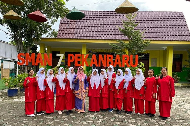 Kepala Sekolah SMA Negeri 7 Pekanbaru Nurhafni (enam dari kiri) berfoto bersama para siswi SMA N 7 Pekanbaru.