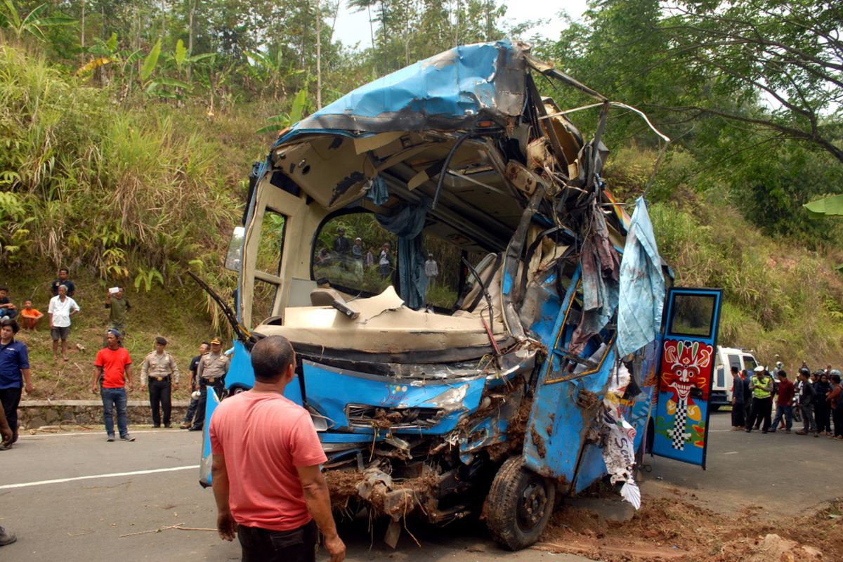 Seorang petugas melihat bangkai mini bus yang masuk jurang setelah dievakuasi di Tanjakan Letter S, Kecamatan Cikidang, Sukabumi, Jawa Barat, Minggu (9/9/2018).