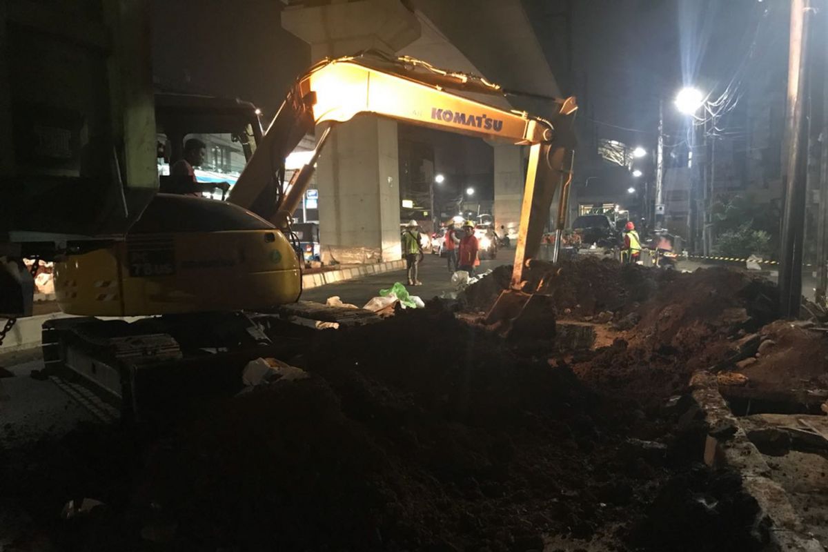 Gundukan tanah dan puing-puing bekas galian yang ada di badan Jalan Fatmawati, Jakarta Selatan, diangkut menggunakan bekhoe, Minggu (22/7/2018).