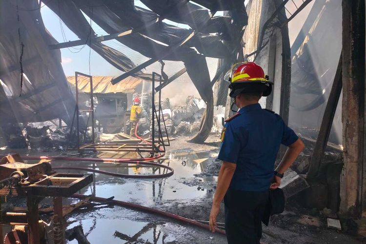 Petugas pemadam kebakaran sedang memadamkan api di pabrik alumunium foil di kawasan industri Gunung Putri, Kabupaten Bogor, Jawa Barat.