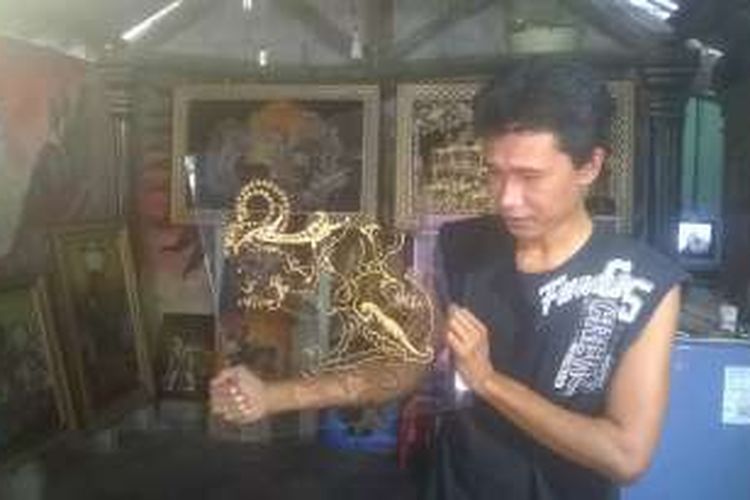 Imron Agus Triyono berada di galerinya di Desa Menang, Pagu, Kabupaten Kediri, Jawa Timur, saat menunjukkan tahapan melukis wayang pada kaca. (M.Agus Fauzul Hakim/ Kompas.com).