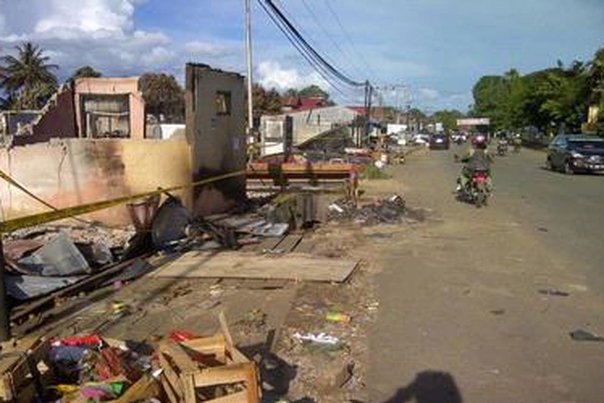 Sejumlah warga melintas di jalan depan pasar Barong Tongkok di Kutai Barat, Kalimantan Timur, Senin (26/11/2012). Pasar Barong Tongkok terbakar dalam kerusuhan pada Sabtu lalu. 
