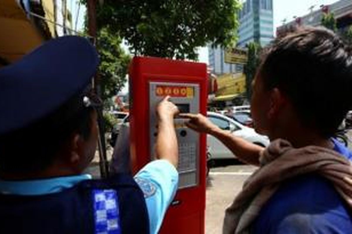 Warga membayar parkir melalui meteran parkir di Jalan H Agus Salim atau lebih dikenal Jalan Sabang, Kebon Sirih, Jakarta Pusat