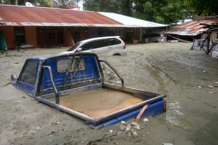 Sejumlah kendaraan terendam lumpur saat banjir bandang di Sentani, Kabupaten Jayapura, Papua, Minggu (17/3/2019). Jumlah korban bencana banjir bandang yang terjadi pada Sabtu (16/3/2019) malam kemarin, hingga data yang masuk pada Minggu sore, terus bertambah menjadi 63 orang.
