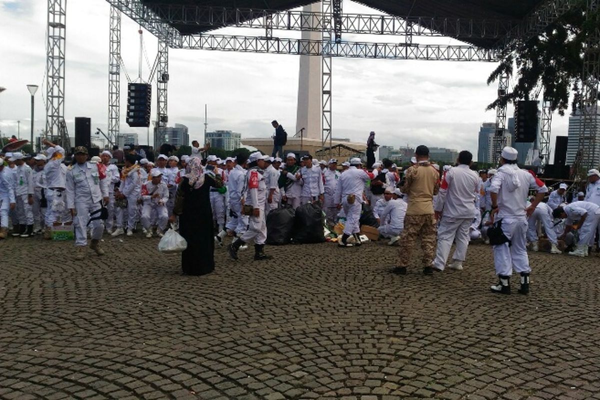 Massa Reuni Alumni 212 membersihkan area Monas dari sampah setelah acara berakhir, Sabtu (2/12/2017) siang.