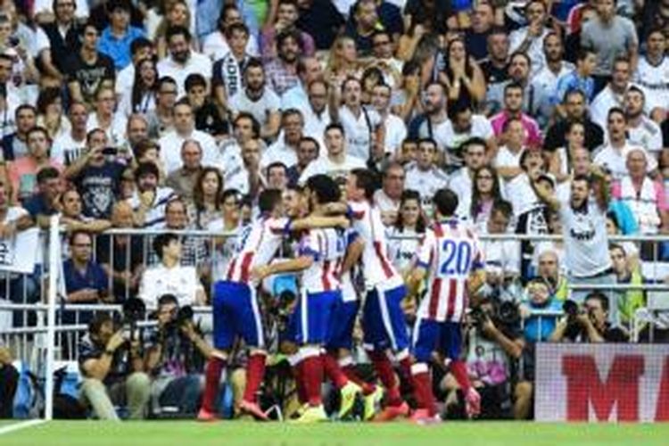 Para pemain Atletico Madrid merayakan gol ke gawang Real Madrid pada laga Primera Division di Stadion Santiago Bernabeu, Madrid, Sabtu (13/9/2014).