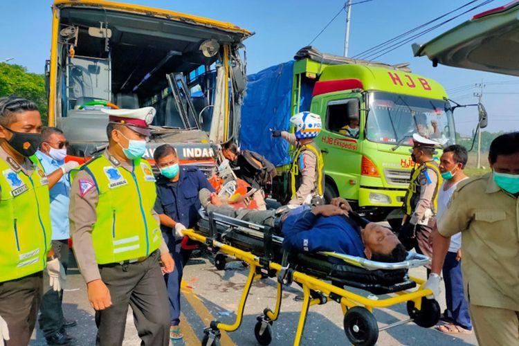 Petugas saat melakukan evakuasi korban tabrakan bus yang terjadi di Jalan Raya Desa Ambeng-ambeng Watangrejo, menuju RSUD Ibnu Sina Gresik, Senin (22/11/2021).